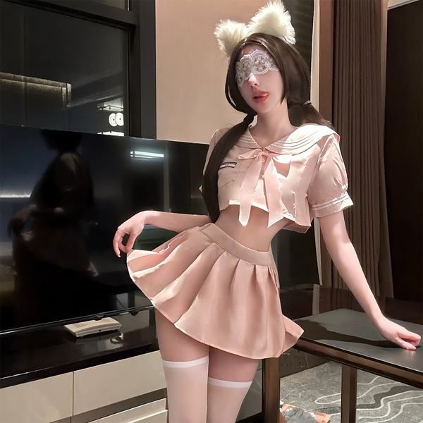 A stylish woman poses in a chic pink jk-style outfit featuring a flirty pleated skirt and matching bra, perfect for luxury se...