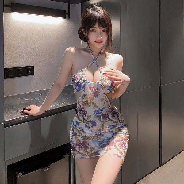 A woman poses confidently in a floral-patterned cherry romance dress, featuring a sexy sheer back design and a form-fitting m...