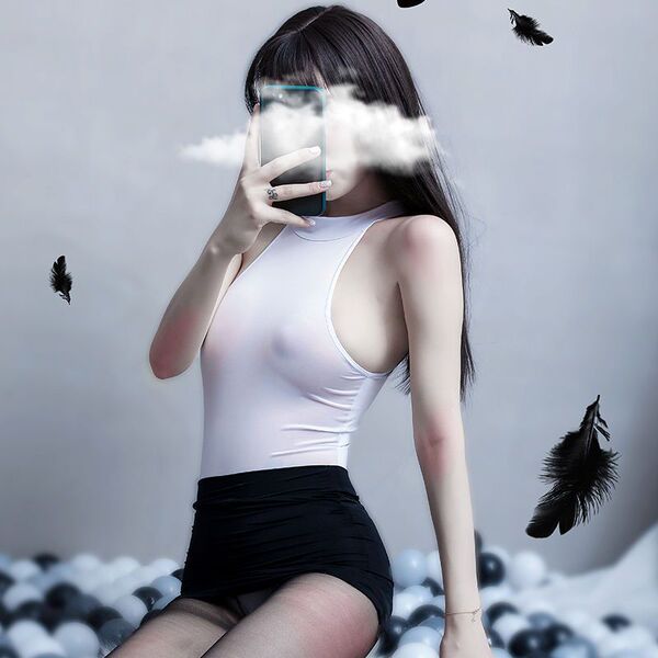 A woman poses with a smartphone, partially obscuring her face as feathers float around her. she wears a white bodysuit paired...