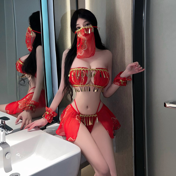A woman poses in a mirror wearing a vibrant red chinese new year-themed exotic dance costume, featuring intricate designs and...