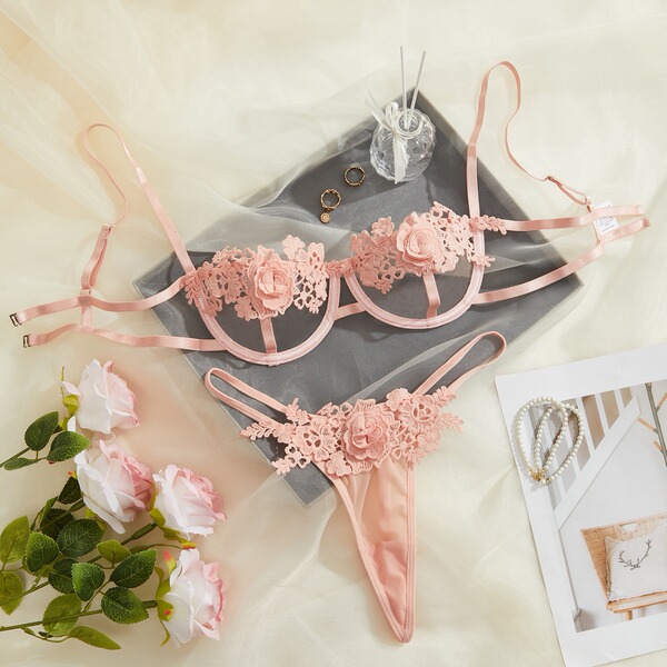 Pink lace lingerie set with floral details, elegant euro-style design for women, displayed with roses and pearls.