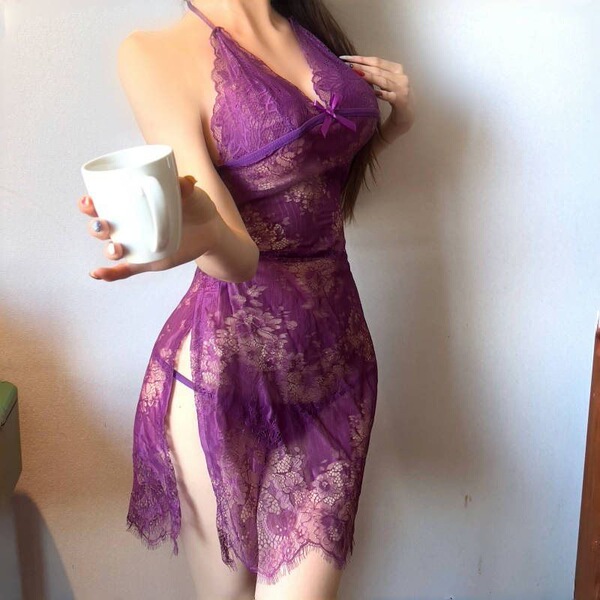 Woman wearing purple lace bodysuit with sheer mesh, cut-outs, and adjustable ties; holds white mug; fits up to 200 lbs.