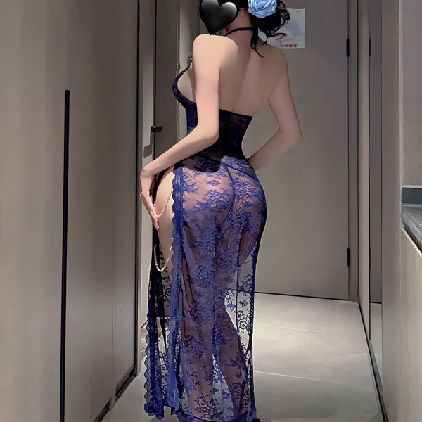 Woman wearing a seductive lace lingerie set with sheer blue floral details and high slit, back view in hallway.