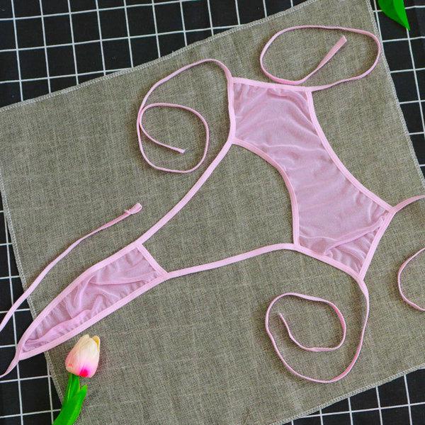 Pink sheer mesh lingerie set with delicate ties, displayed on a textured surface alongside a tulip flower.