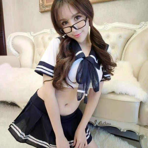 Woman in sailor uniform role play costume set, featuring a cropped top with bow and pleated skirt, ideal for cosplay and adul...
