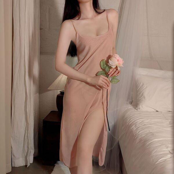 Woman in pink mesh slip dress with high split, holding rose by bed. sheer temptation lingerie nightgown set for women.
