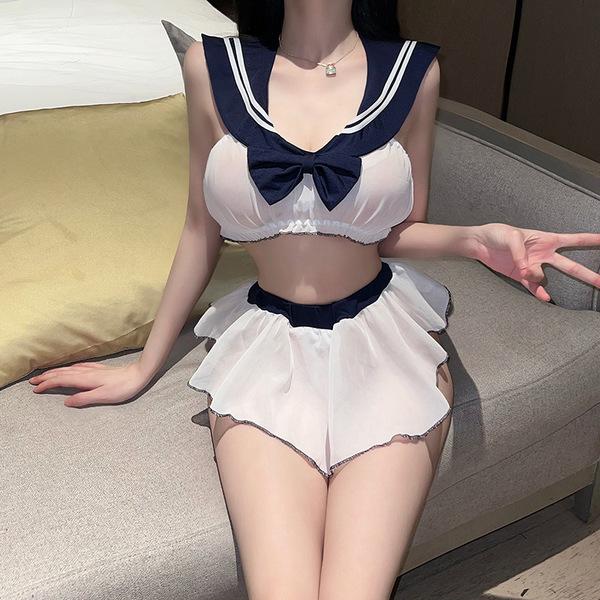 A woman models the flower moon seduction lingerie set, featuring a sailor-style top with a navy blue bow and white skirt, per...
