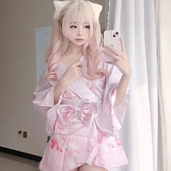 A woman poses in a pink floral kimono-style cosplay outfit, featuring a deep v neckline and large bow accents, perfect for fa...
