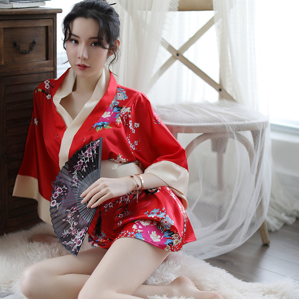 A woman poses elegantly in a vibrant red japanese kimono, featuring floral patterns and traditional design elements, perfect ...
