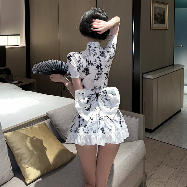 A woman stands facing away from the camera, wearing a white chinese new year-themed sexy lingerie dress inspired by a red qip...