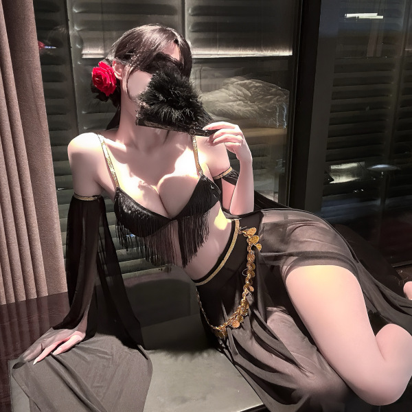 Woman in black lingerie set with gold accents, holding feather fan, red rose in hair, elegant and sensual look.