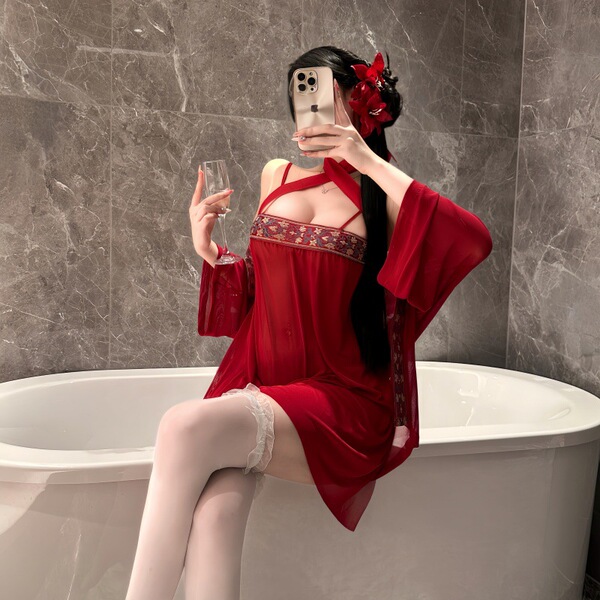 Woman in red feiniao moon-gazing hanfu lingerie set with sheer sleeves, holding wine glass by bathtub.