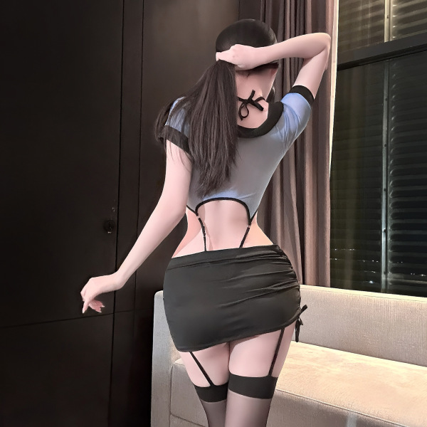 Woman wearing flirty lace peek-a-boo lingerie set with sheer stockings, back view showing open design and front snap closure.