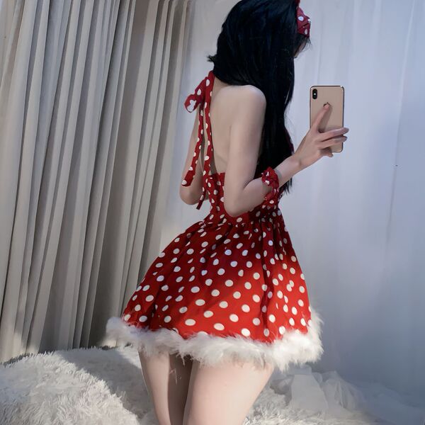 A woman poses in a festive red dress adorned with white polka dots, featuring a fluffy hem and tie-backs, perfect for new yea...