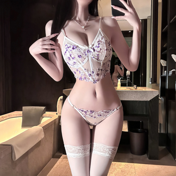Woman wearing golden night lace embroidery lingerie set with floral push-up bra, thong, and lace thigh-highs in bathroom.