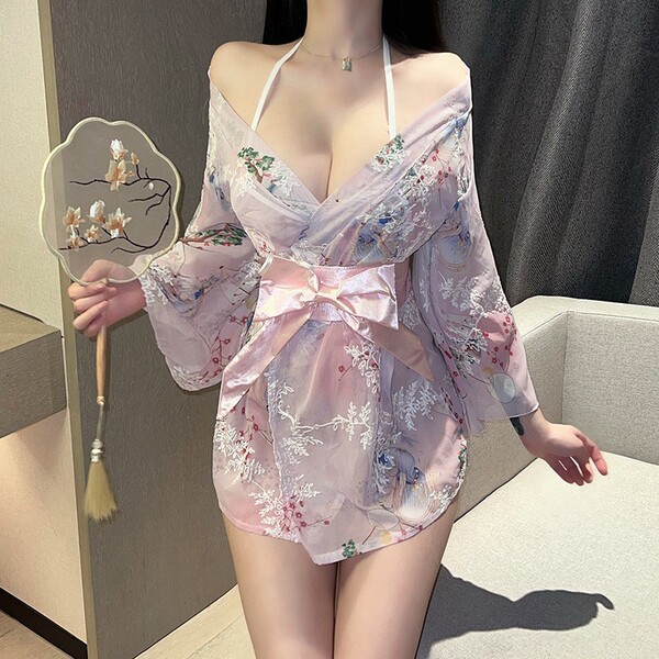 Woman wearing pink floral japanese-style sleepwear set with bow, holding a decorative fan.