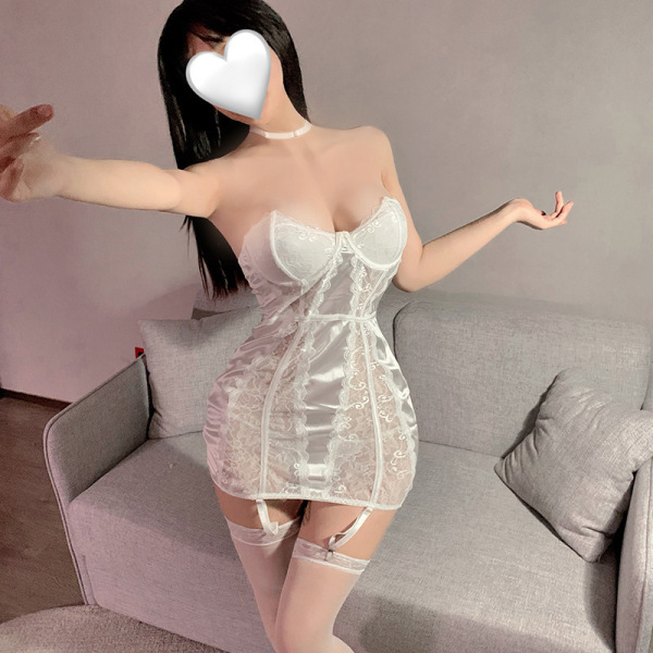 Woman wearing a white lace halter bodycon mini dress with satin accents and matching thigh-high stockings, posing indoors.