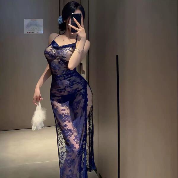 Woman wearing navy blue lace sleepwear, holding a feather accessory, in a mirror selfie.