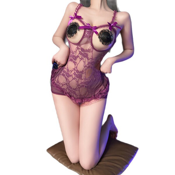 Woman kneeling in purple lace bodysuit with floral trim, sheer mesh, open-crotch design, and vintage uniform-style straps.