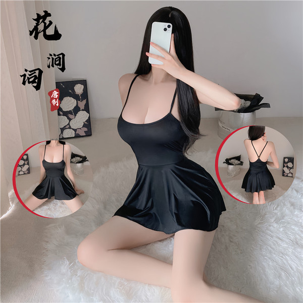 A woman poses in a black cami dress with a backless design, showcasing its sheer lace details. the dress features spaghetti s...