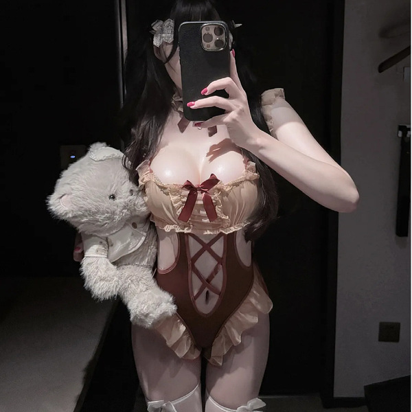 Woman in pure & playful lingerie bodysuit holding teddy bear, soft cute open-crotch sleepwear with adjustable straps.