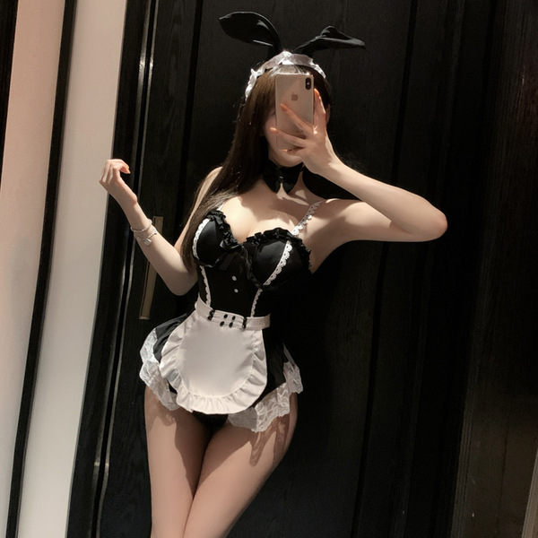 Woman in black and white maid lingerie set with bunny ears, posing seductively for mirror selfie.