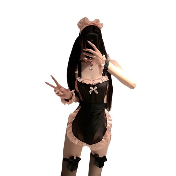 Woman in black and pink maid lingerie set with bow details, posing playfully for bedroom role play and sensual wear.