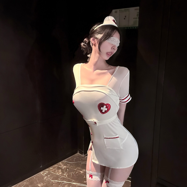 Woman wearing white nurse costume lingerie with red cross heart, sheer sleeves, garter stockings, and lace blindfold.