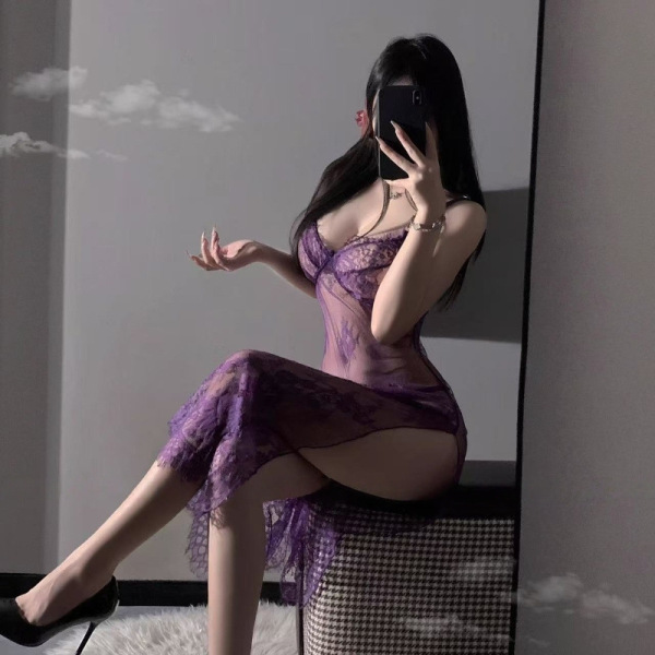 Woman wearing purple lace lingerie set with sheer straps, slit skirt, and uniform-inspired design, posing in mirror selfie.