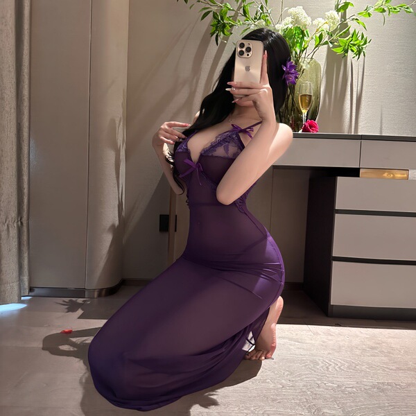 A woman poses in a luxurious purple sheer lace nightgown, featuring a seductive design perfect for date nights and sleep. the...