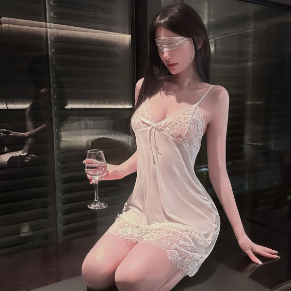 Woman in qingshe sheer lace lingerie set with peekaboo bust, holding wine glass, blindfolded, kneeling on dark surface.