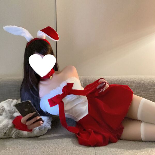 Woman lounging on a couch in a qqny christmas sexy bunny girl dress costume set, featuring a red and white outfit with bunny ...