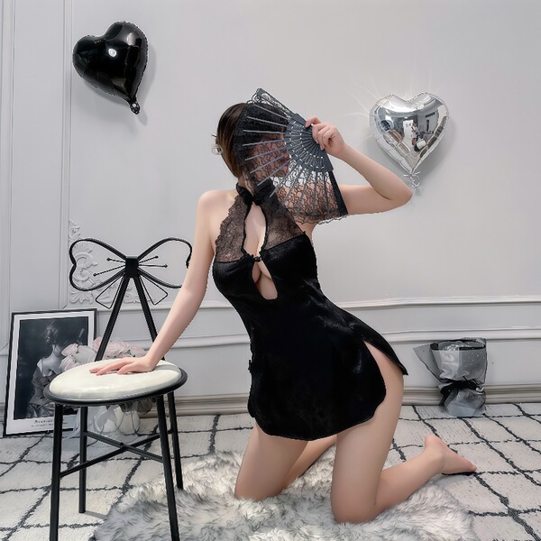 Woman in black retro lace cheongsam lingerie with sheer mesh back, kneeling beside stool with heart balloons.