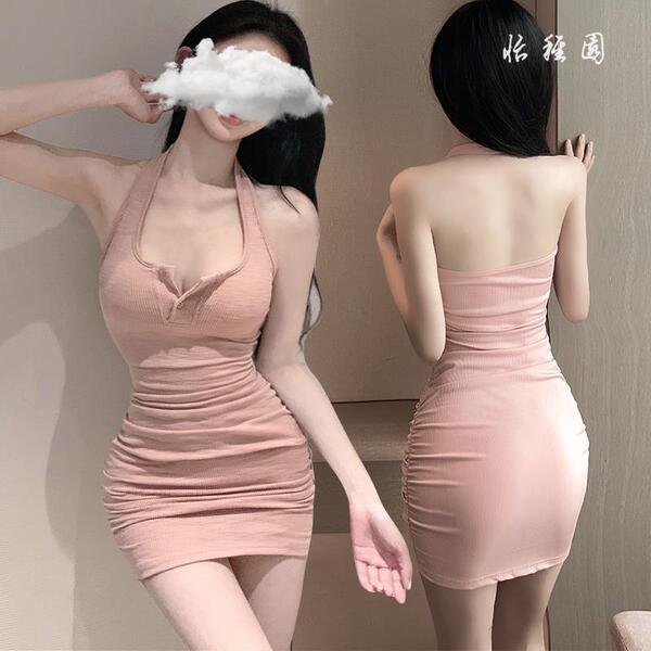 Woman modeling pink bodycon mini dress with ruched detail, featuring a halter neckline and open back design.