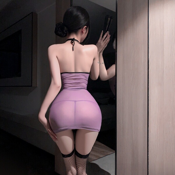 Woman in purple sheer lingerie set with lace trim, back view showing retro erotic nightgown outfit and fishnet stockings.