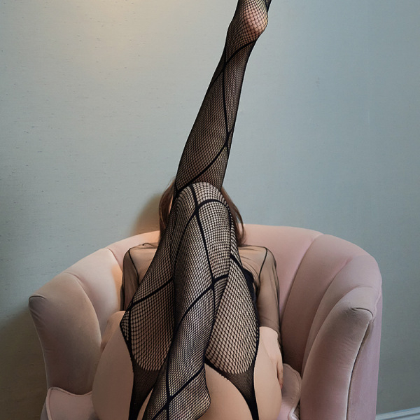 Woman lounging in a pink chair wearing yeqingge sexy lace open-crotch bodystocking with sheer mesh stockings, showcasing allu...