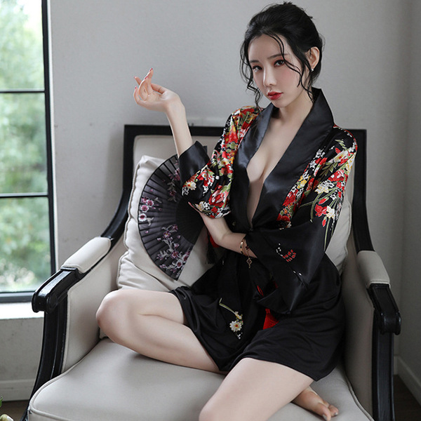 A woman sits on a chair wearing a japanese kimono-style lingerie set with floral patterns, featuring a deep v neckline and no...