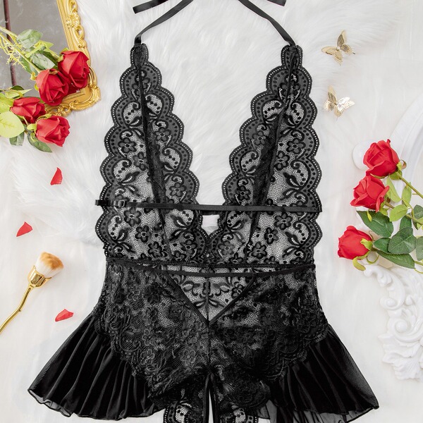 Luxury black lace bodysuit with sheer panels and scalloped edges, styled on white fur with red roses and gold accents.