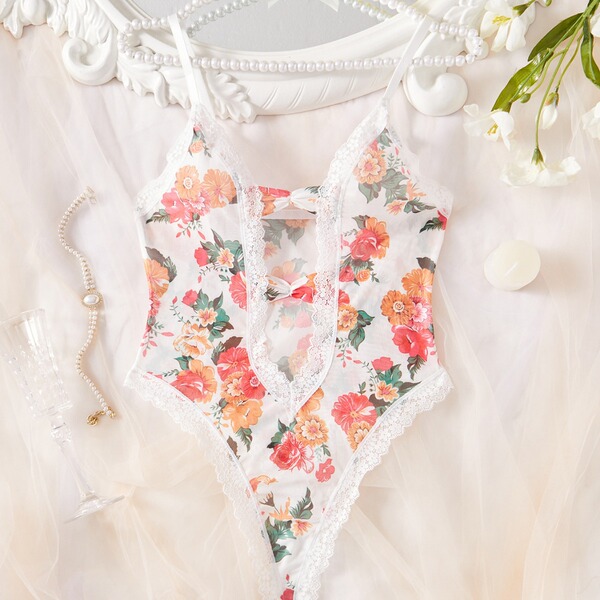 Floral lace sheer bodysuit for women, featuring delicate embroidery and transparent design, styled with pearls and flowers.