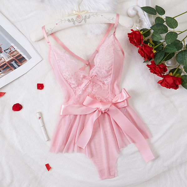 Pink lace sheer bodysuit for women, featuring delicate floral embroidery and a satin bow, styled with red roses on a white be...