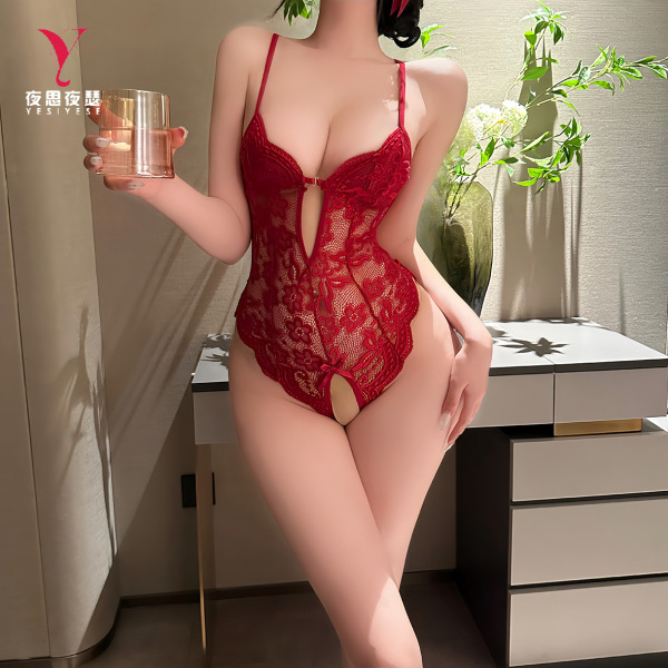 Woman modeling red nightsigh lace sexy bodysuit with open-crotch design, holding glass in elegant bedroom setting.