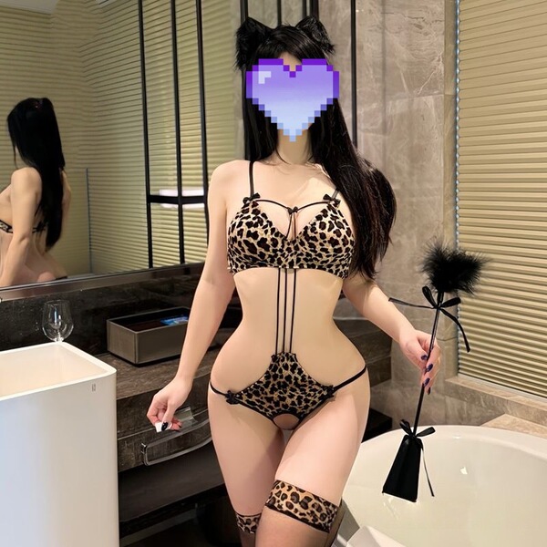 Woman wearing plus size leopard print lace bodysuit with open-crotch tie-up design, cat ears, and matching garter belt in bat...