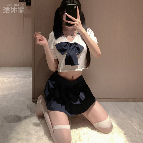 A person wearing a japanese-style school uniform, featuring a white top with a navy bow and pleated skirt, paired with sheer ...