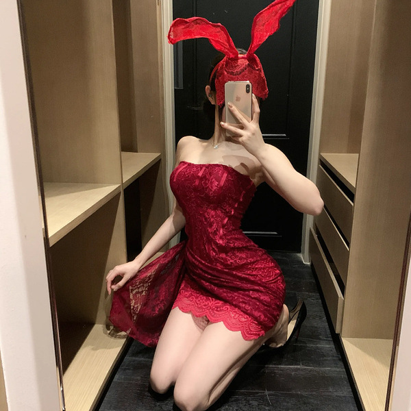 A woman poses in a mirror wearing a red lace dress with bunny ears, capturing a playful and elegant moment. the dress feature...