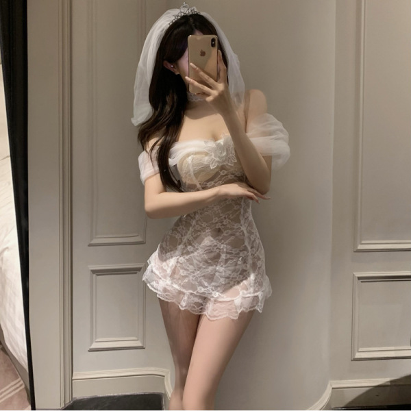 Woman in mirror wearing white sheer lace bridal lingerie set with off-shoulder sleeves and veil, romantic sleepwear style.
