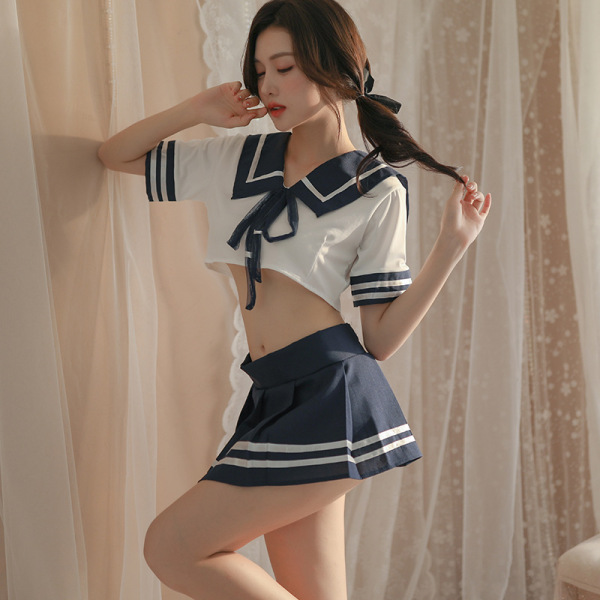 Curvy woman modeling a sexy jk uniform lingerie set with white crop top and navy pleated skirt, factory direct.