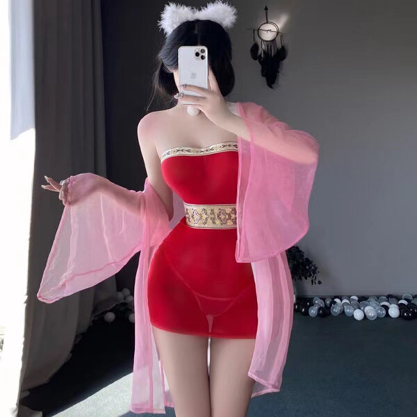 A woman poses in a red bodysuit paired with a sheer pink robe, embodying a fox spirit theme. the set features intricate desig...