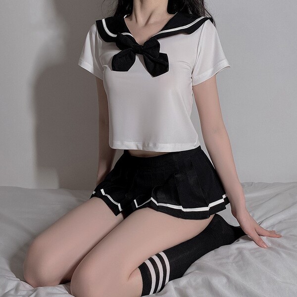 Sexy innocent schoolgirl lingerie set featuring a pleated mini skirt, sailor-style top with bow, and knee-high socks, perfect...