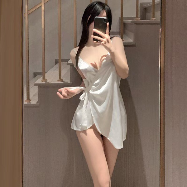 A woman poses in a white satin nightgown with lace-up details, featuring a v-neck design and ice silk fabric, perfect for sum...