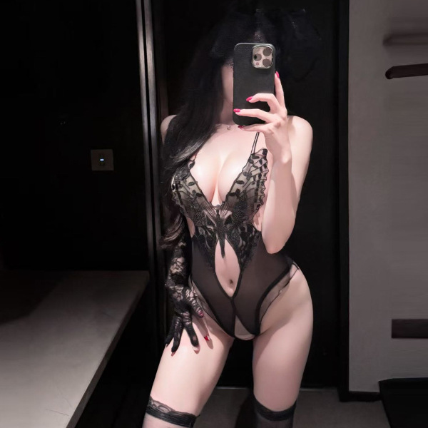 Woman wearing a sexy sheer lace bodysuit with butterfly detail, open-crotch design, and tight fit for small bust.